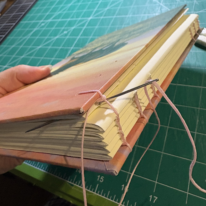 Stitch last signature and cover together